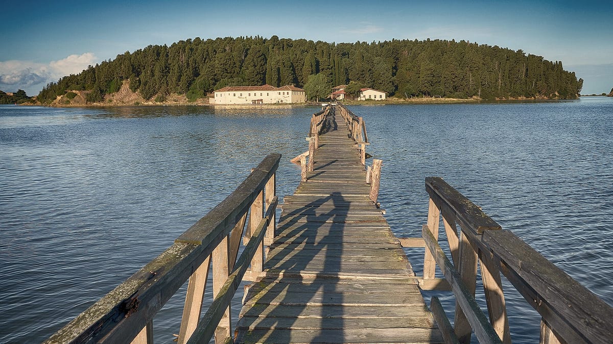 Holzsteg zur Klosterinsel Zvërnec in einer stillen Lagune in Albanien