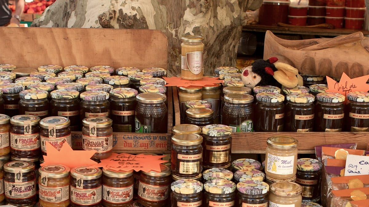 Marktstand voller Honiggläser in warmem Licht