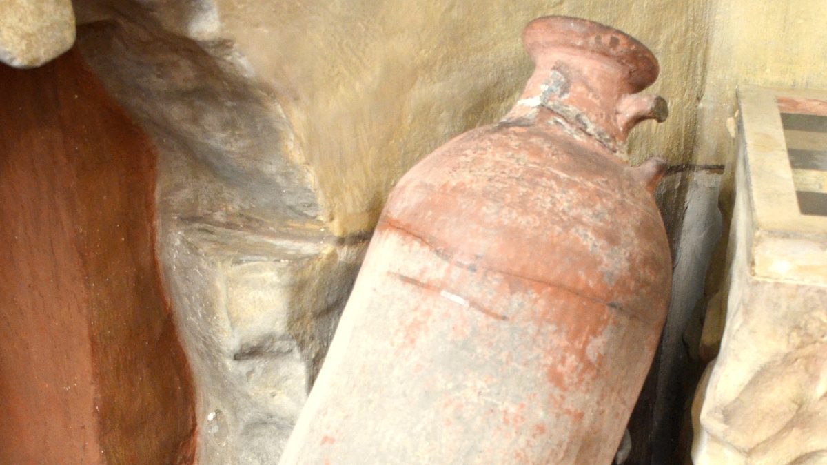 Antike römische Weinamphore aus Ton an einer Steinwand