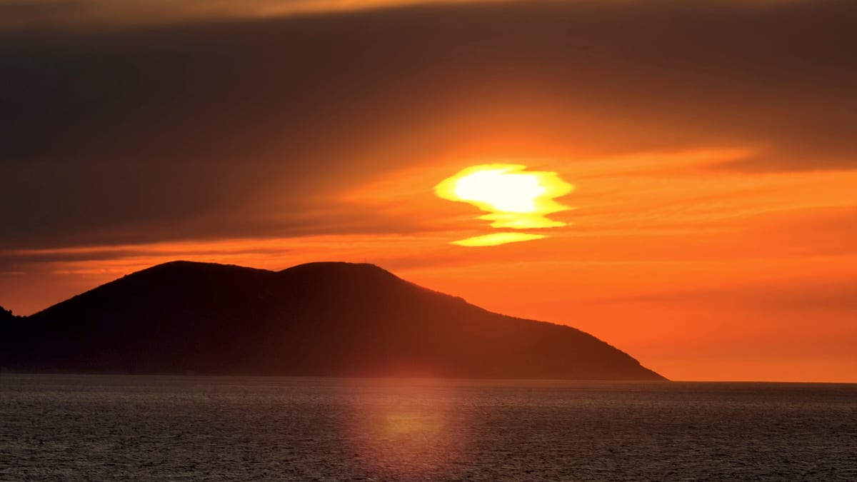 Leuchtend orangefarbener Sonnenuntergang über dem Ionischen Meer bei Vlora