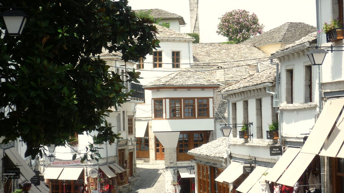 Sonnige Basargasse in Gjirokaster mit Steinhäusern und Läden