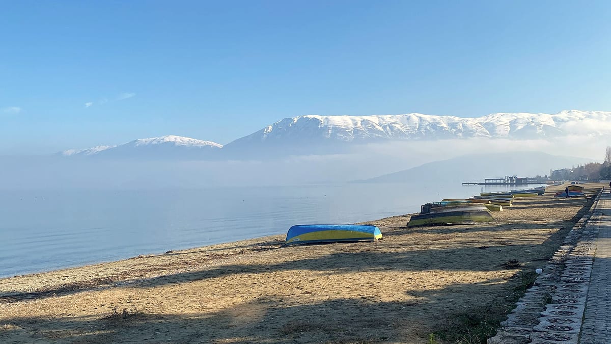 Der Ohridsee bei Pogradec nahe der Weinregion Korça, mit schneebedeckten Bergen